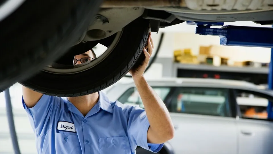 Seattle, Washington State, USA --- Mechanic working on car --- Image by © ColorBlind Images/Blend Images/Corbis