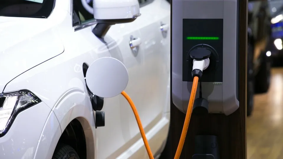 Power supply for electric car charging. Electric car charging station. Close up of the power supply plugged into an electric car being charged. - Stromversorgung zum Aufladen von Elektroautos. Ladestation für Elektroautos. Schließen Sie oben von der Str