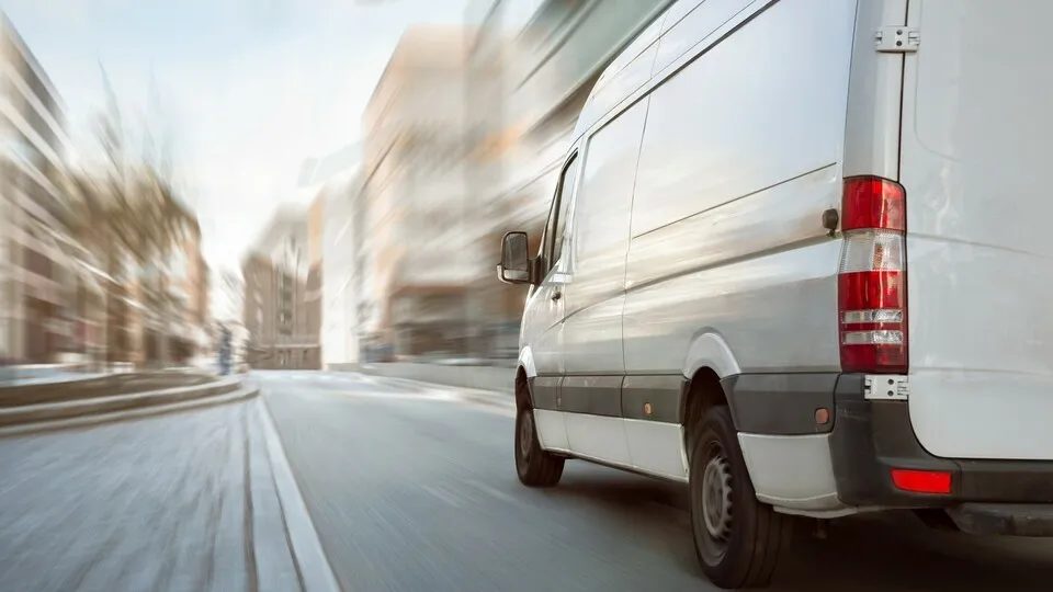 Transporter fährt auf einer sonst leeren Straße in der Stadt