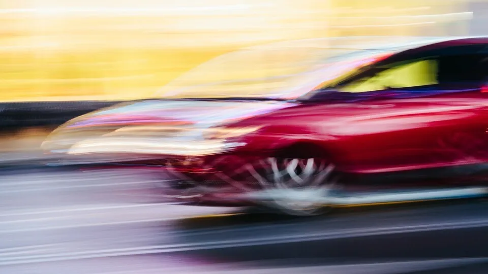 Red Sports Car in a Blurred City Scene
