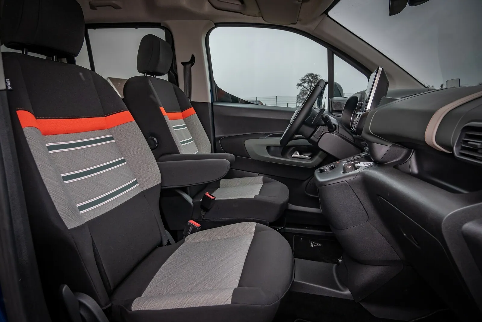 Sportif: Mit orangen Akzenten auf den liniert gemusterten Komfort-Stoffsitzen versprüht der Berlingo eine gewisse Frische.