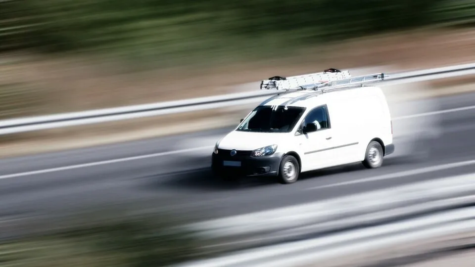 Nutzfahrzeug mit Leiter auf dem Dach im Straßenverkehr