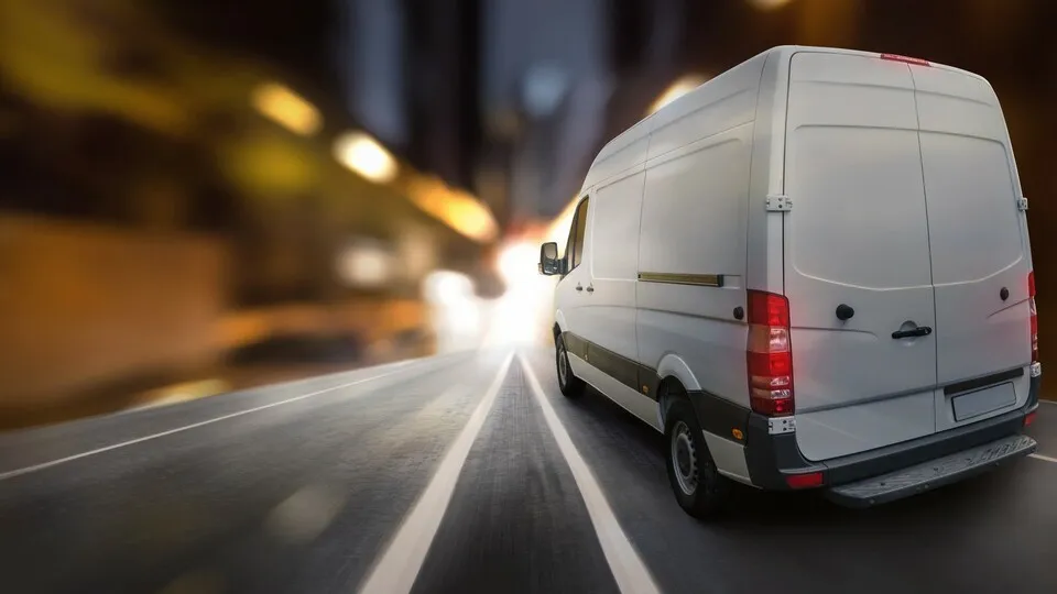 Ein Transporter fährt durch die Nacht.