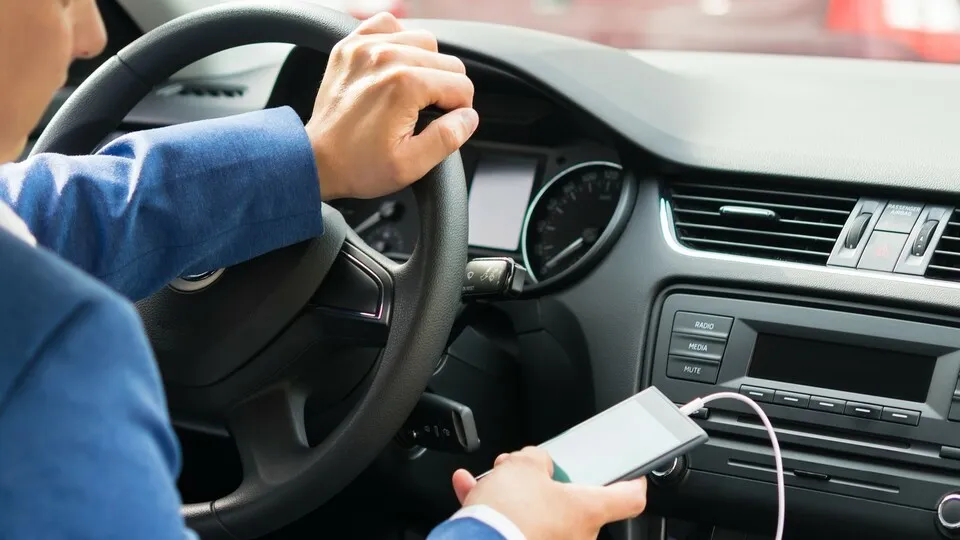 Mann im Auto telefoniert mit dem Handy