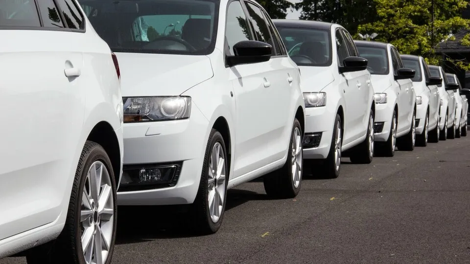 Weiße Autos hintereinander stehend auf einer Straße