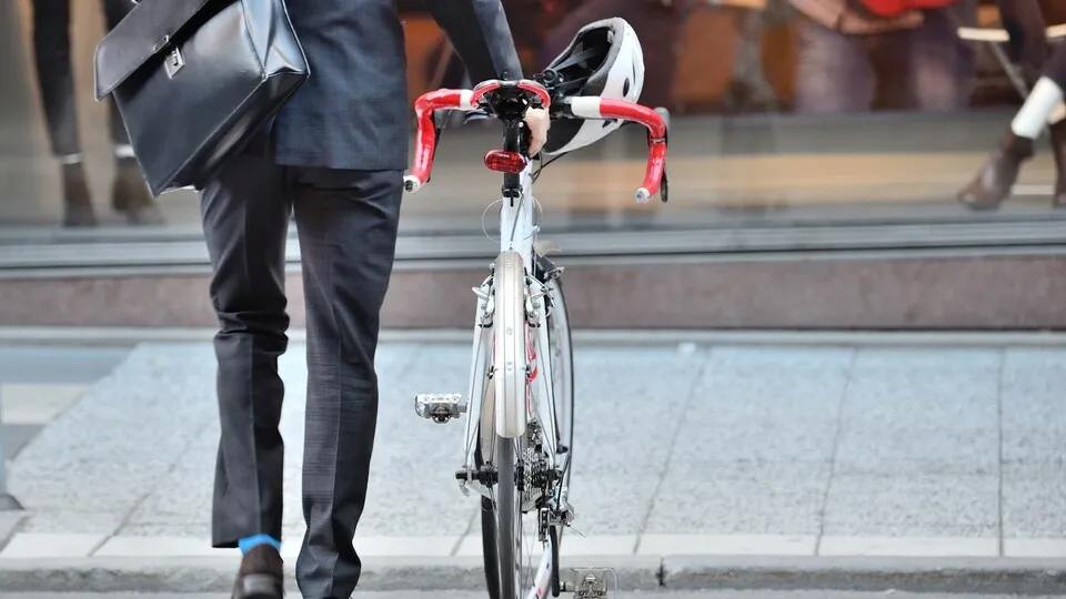 Anzugträger schiebt sein FahrradOffice worker on his way home with bike