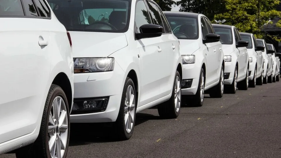 Weiße Autos hintereinander stehend auf einer Straße
