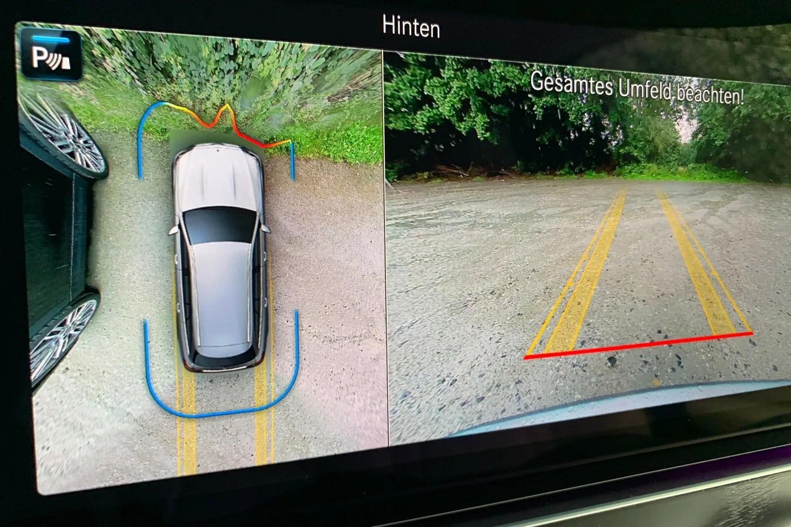 Besonders das Update bei der Einparkhilfe gefällt. Das große Paket mit 360-Grad-Kamera zeichnet jetzt einen virtuellen „Schutzschild“ ums Auto. Er bekommt „Dellen“ und verändert die Farbe, wo wir uns einem Hindernis nähern. Das hilft tatsächlich beim exakten Einschätzen der Parklücke.