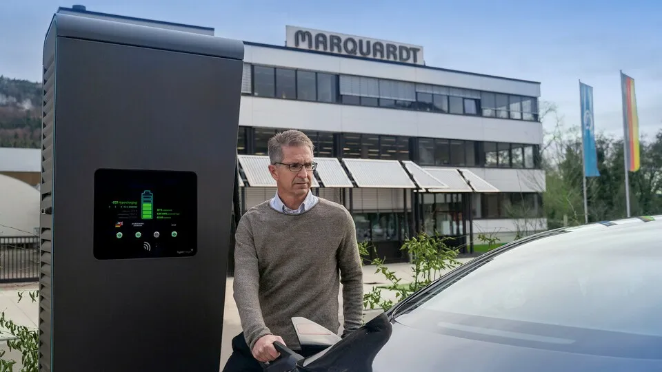 Jochen Schweickhardt, Prokurist und Nachhaltigkeitsbeauftragter bei Marquardt, beim Laden eines E-Autos.