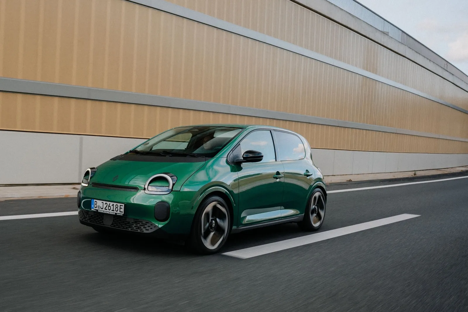 Grüner Renault Twingo Electric während der Fahrt, aufgenommen schräg von vorne.