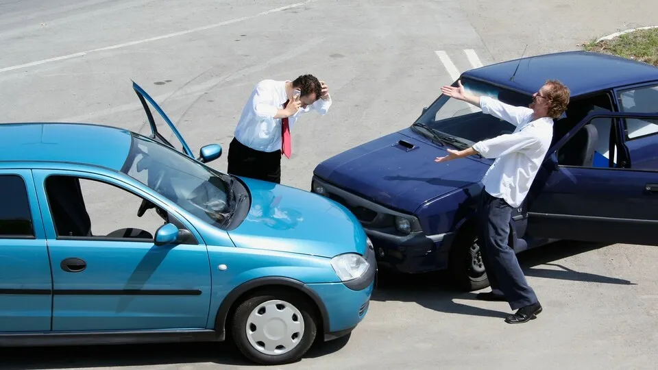 Autounfall mit zwei BeteiligtenTraffic accident - one driver on the mobile phone, second expressing anger