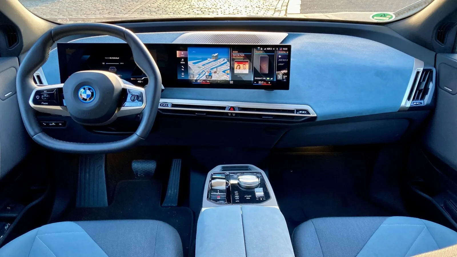 Immer Serie im BMW iX: 12,3-Zoll-Digitalinstrumente und zum Fahrer gebogener 14,9-Zoll-Touchscreen. Das Lederimitat Sensatec überzeugt.