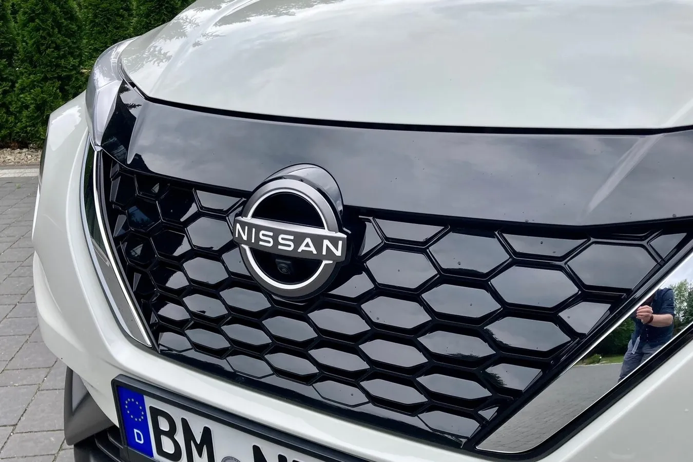 Kunststoffblende im oberen Teil des Grills als Erkennungszeichen für elektrifizierte und elektrische Nissan-Modelle.