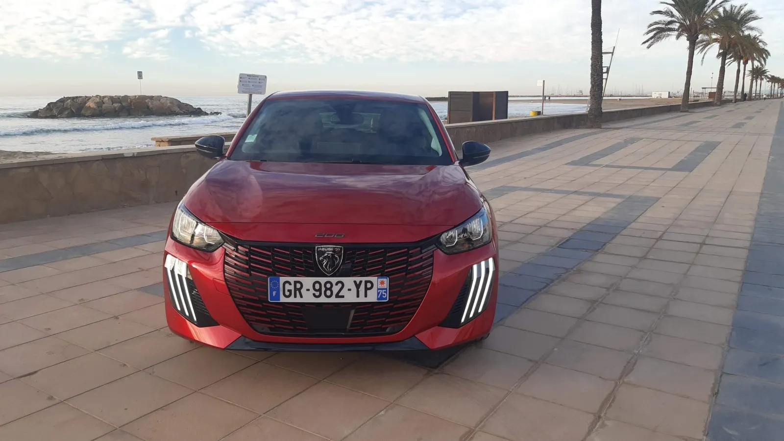 Von vorn ist der geliftete Peugeot E-208 am neuen Grill mit drei vertikalen Lichtkrallen zu erkennen.