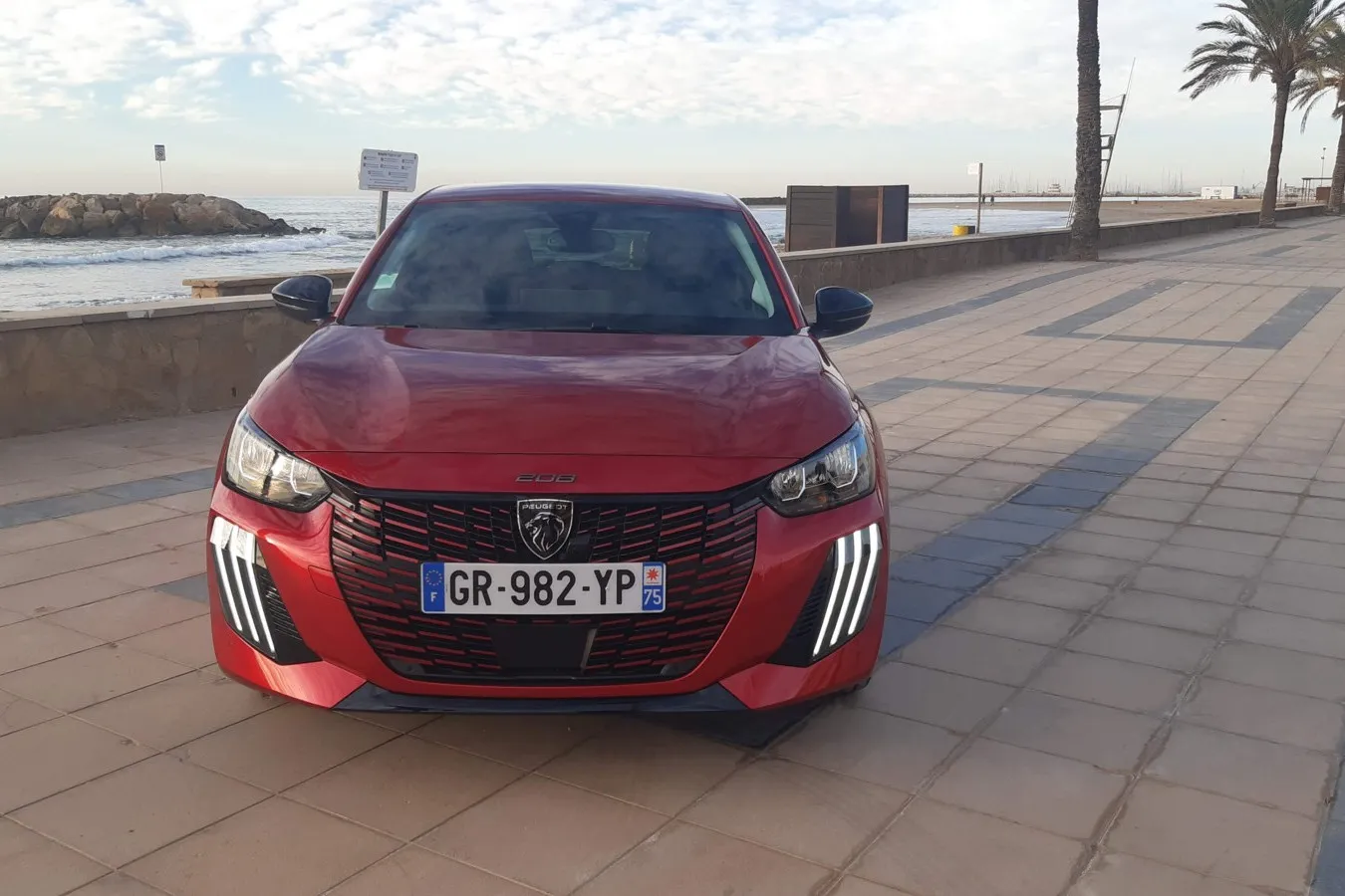Von vorn ist der geliftete Peugeot E-208 am neuen Grill mit drei vertikalen Lichtkrallen zu erkennen.