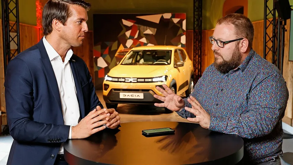 Thilo Schmidt, Geschäftsführer von Dacia in Deutschland (links), im Gespräch mit bfp-Chefredakteur Sven Eisenkrämer. Im Hintergrund: Der neue batterieelektrische Dacia Spring, der auch den Flottenmarkt erobern soll.